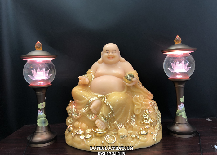 Tượng Phật Di Lặc ngồi đứng với y áo viền vàng sang trọng, đế tượng tạo hình đám mây được điểm nhiều thỏi vàng, đồng vàng lấp lánh
